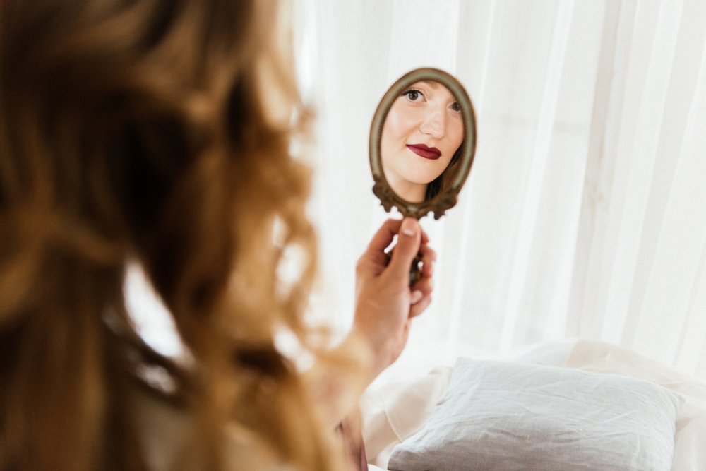 a woman looks in the mirror