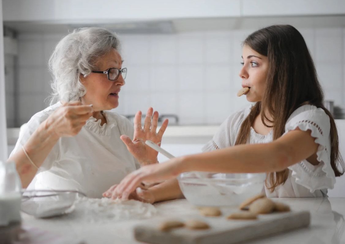 grandmother and granddaughter are sitting at the table