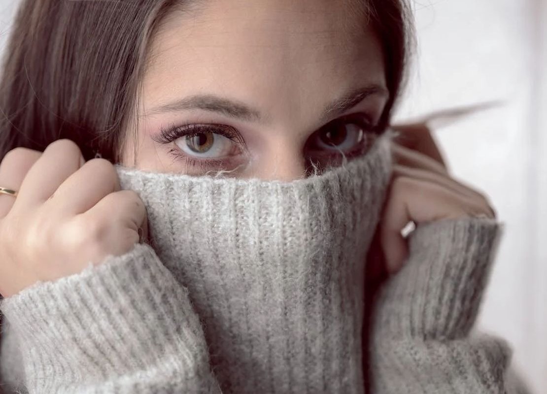 a girl pulls a sweater over her face