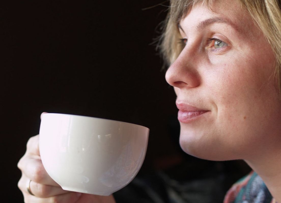 woman drinking from a cup