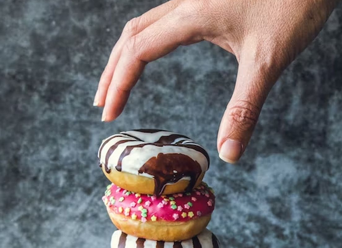 hand reaches for donuts