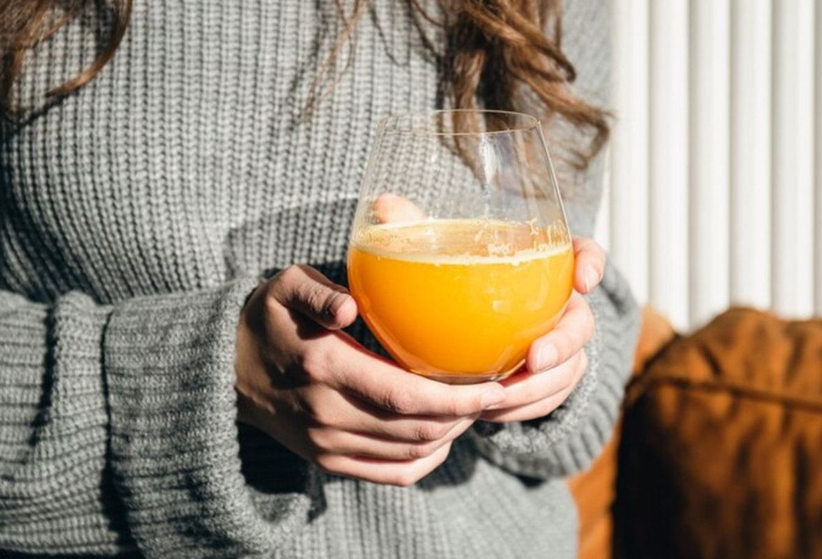 a glass of juice in hands