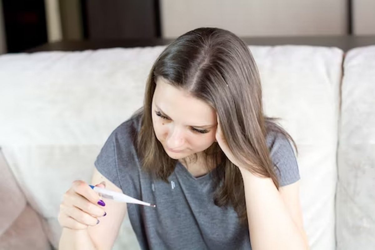 a woman is holding a thermometer