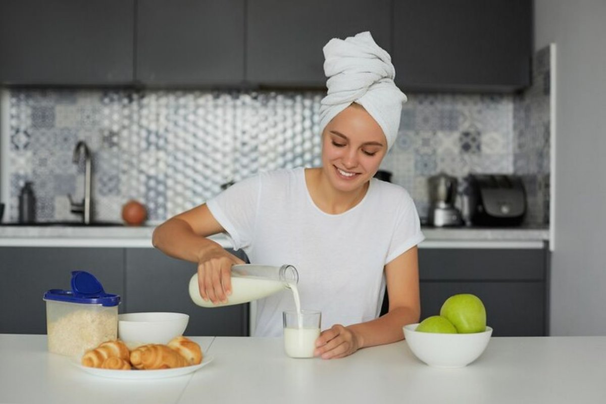 a woman pours milk into a glass