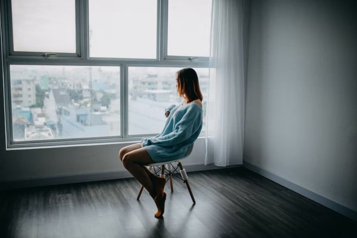 a young woman is sitting by the window