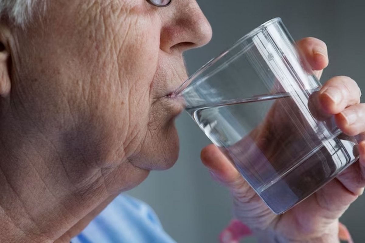 an elderly person drinks water