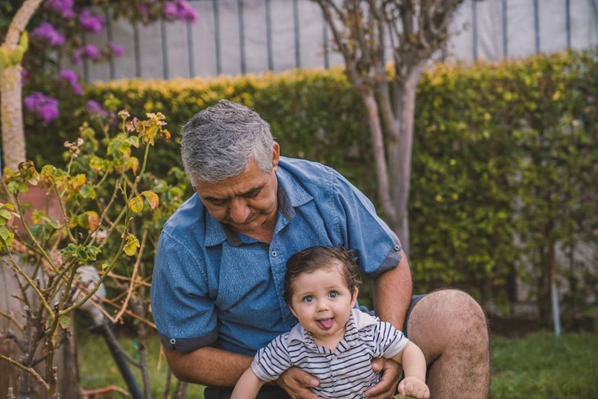 an elderly man plays with his grandson