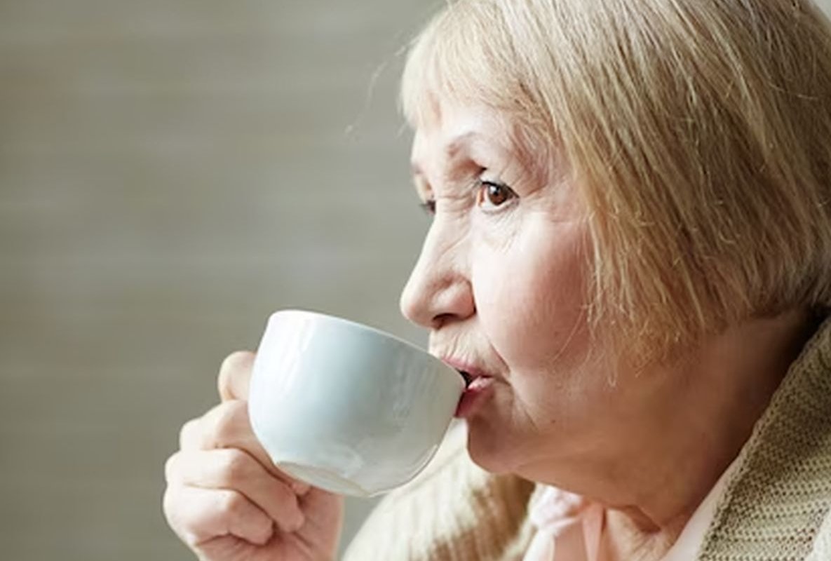 an elderly woman drinks tea