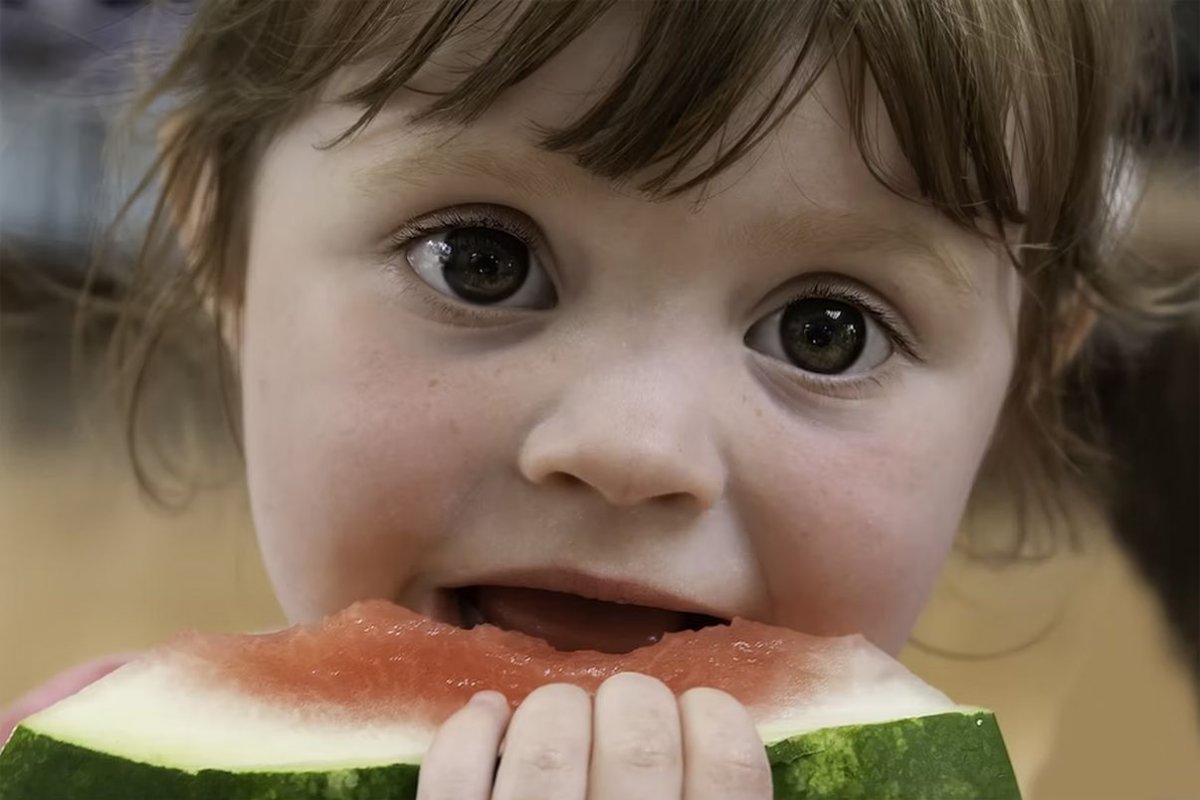 child eats watermelon