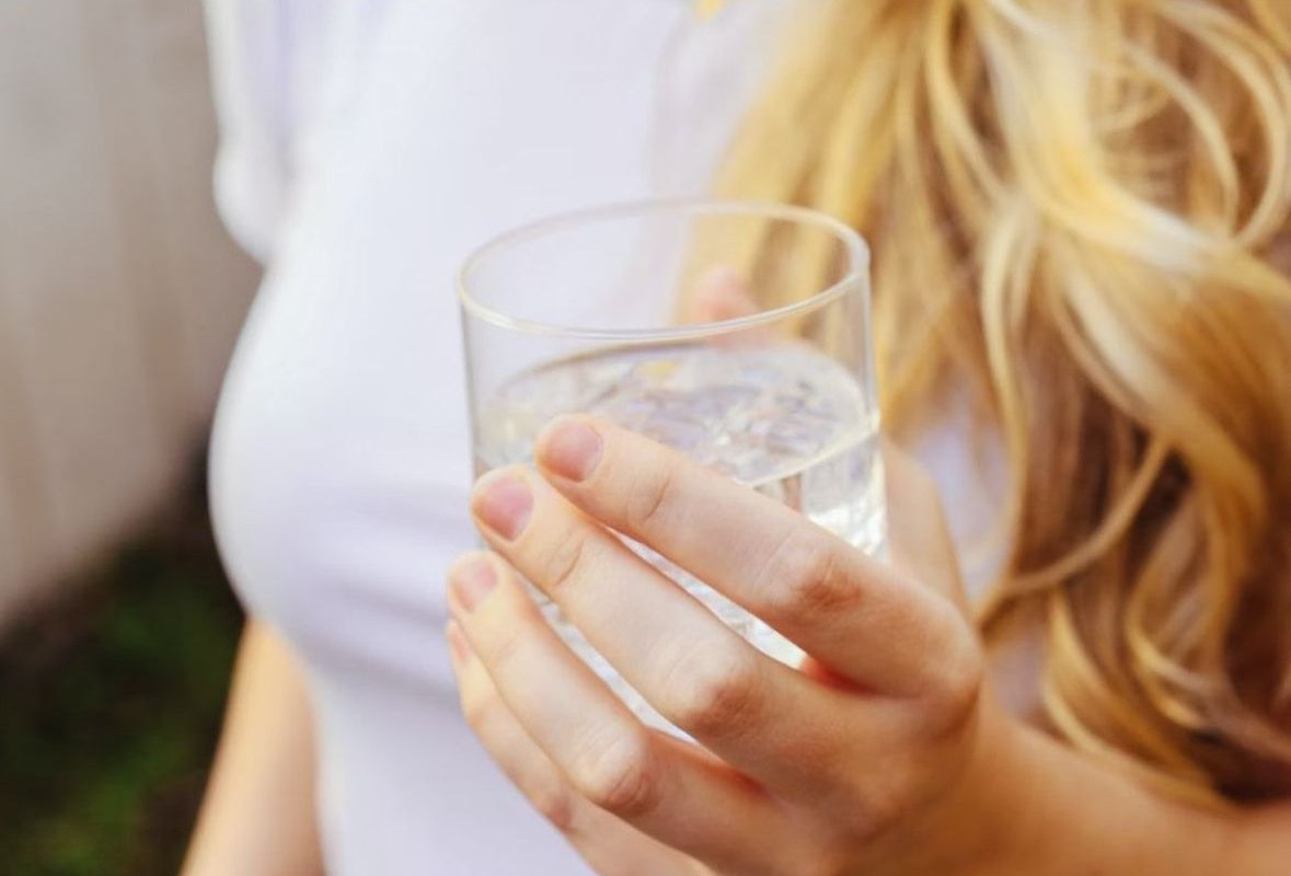 a glass of water in hand